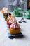 Vertical closeup shot of small cupcakes in a row on a folded kitchen towel