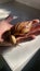 Vertical closeup shot of a snail with a brown patterned shell in the palm of a person