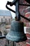 Vertical closeup shot of a stone bell hanged on the wall of a cobblestone building