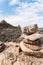 Vertical closeup shot of stones stacked on each other with blurry hills in the background