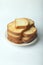 Vertical closeup of slices of loaf bread carefully stacked like a small tower on a white plate