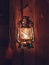 Vertical closeup of a vintage lantern illuminating in the dark