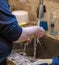 Vertical closeup of a woman washing dishes in farmhouse sink