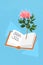 Vertical collage image of opened novel story book fresh flower isolated on painted blue background