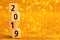 Vertical column of numbers 2019 on golden sparkling background.