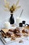 vertical composition. Appetizing crumbly meringue with chocolate and coconut sprinkles, milk in glasses and decor on a