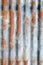 Vertical corrugated iron sheet with patches of rust