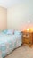 Vertical Cozy bedroom with twin bed, carpet and himalayan sea salt lamp on the nightstand