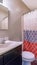 Vertical crop Home bathroom with toilet vanity area and bathtub conceled by colorful curtain