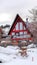 Vertical crop Home on a hill with snowed in balcony and yard against cloudy sky in winter