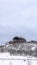 Vertical crop Home on top of a hill with leafless plants and fresh snow on the slope in winter