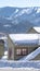 Vertical crop Snow covered pitched roof top of home against blurry mountain and sky in winter