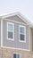 Vertical crop Snowy roof brick wall and vertical siding at exterior of townhome against sky