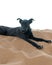 Vertical of a cute black dog resting on the hot sands of Sahara Desert in Morocco