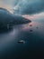 Vertical drone shot of boats and ships floating on water by the shoreline with Positano, Italy