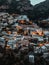 Vertical drone shot of the illuminated village and commune of Positano, Italy stretching over hills