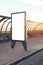 Vertical empty billboard placeholder template on the city bus stop outdoor, information banner template, space for mockup layout