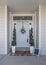 Vertical Entrance of a house with decorative light blue front door and posts with stone bricks