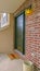 Vertical Facade of a home with a small porch and classic red brick wall