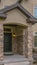 Vertical Facade of a home with stone wall and welcoming covered front porch