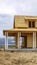 Vertical Facade of home under construction against snowy mountain and cloudy sky