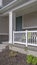 Vertical Facade of a home with view of the porch green front door and white garage door