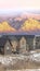 Vertical Facade of homes with snowy sunlit mountain and calm lake background at sunset