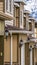 Vertical Facade of townhouses with close up view of garage doors flanked with wall lamps