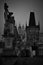 Vertical film grained black and white picture of Charles bridge in Prague, Chec Republic on the dusk. Old fashioned