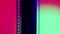 Vertical film strip on a pink and green gradient background, close up. 35mm film slide frame. Long, retro film strip