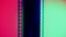 Vertical film strip on a red and green background, close up. 35mm film slide frame. Long, retro film strip frame. Copy