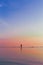 Vertical of fishermen catching fish in the sea using fishing net at sunset.