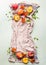 Vertical food background with fresh whole and half peaches on kitchen towel with leaves, flowers and copy space for your design or