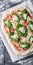 Vertical food banner Raw Pizza Margherita with basil on a cutting board. Close-up. Top view