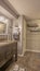 Vertical frame Bathroom with vanity facing the bathtub and shower behind the white curtain