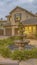 Vertical frame Beautiful tiered fountain at the garden of a home against sky with gray clouds