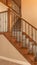Vertical frame Carpeted stairs with wood handrail and metal railing inside an empty new home