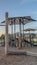 Vertical frame Childrens playground at a park with swings slides and umbrellas viewed at sunset