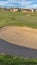 Vertical frame Close up view of a sand trap at a sunny golf course with houses in the distance