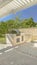 Vertical frame Concrete patio of a home with barbecue grill and white wooden pergola