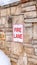 Vertical frame Fire Lane sign on stone retaining wall amid thick fresh snow on a hill in winter