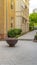 Vertical frame Fire pit on circular patio outside building with white and stone brick wall