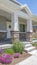 Vertical frame Home facade with plants flowers and pathway on the yard in front of the poch