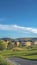 Vertical frame Houses around a golf course with scenic background of mountain and blue sky