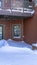 Vertical frame Mountain home facade with balcony over double glass doors and snowy entrance