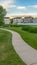 Vertical frame Pictresque park with pond and pathways in front of multi storey family homes