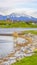 Vertical frame Picturesque lake scenery with wooden deck and rocks on the grassy shore