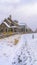 Vertical frame Row of charming houses with snowy yards inside the wooden fences in winter