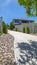 Vertical frame Tree in the middle of a concrete and stone pathway against homes and blue sky