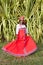 The vertical full body of a joyful African American woman in a bright colorful national Russian dress